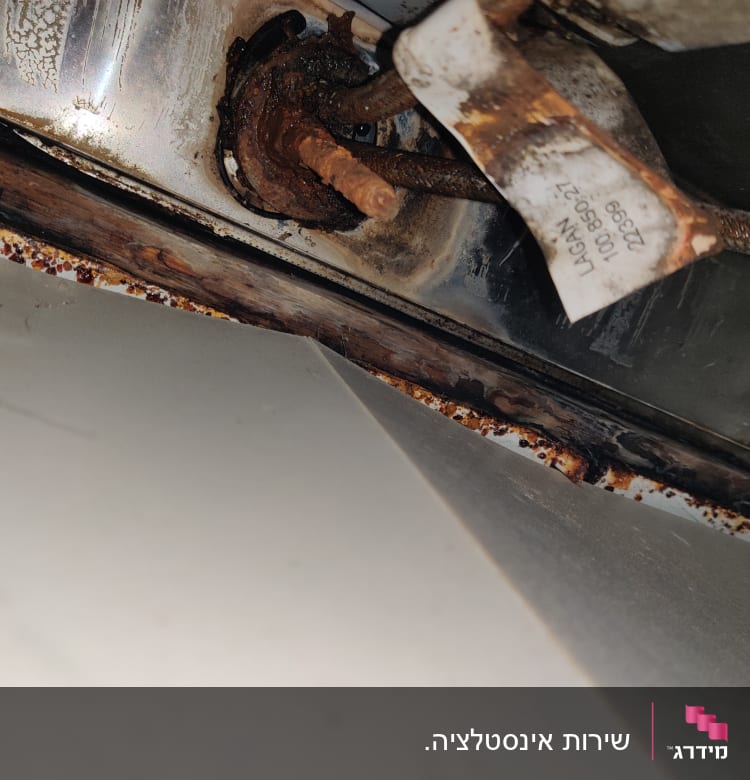 צינור חלוד עם סימני קורוזיה מתחת לכיור